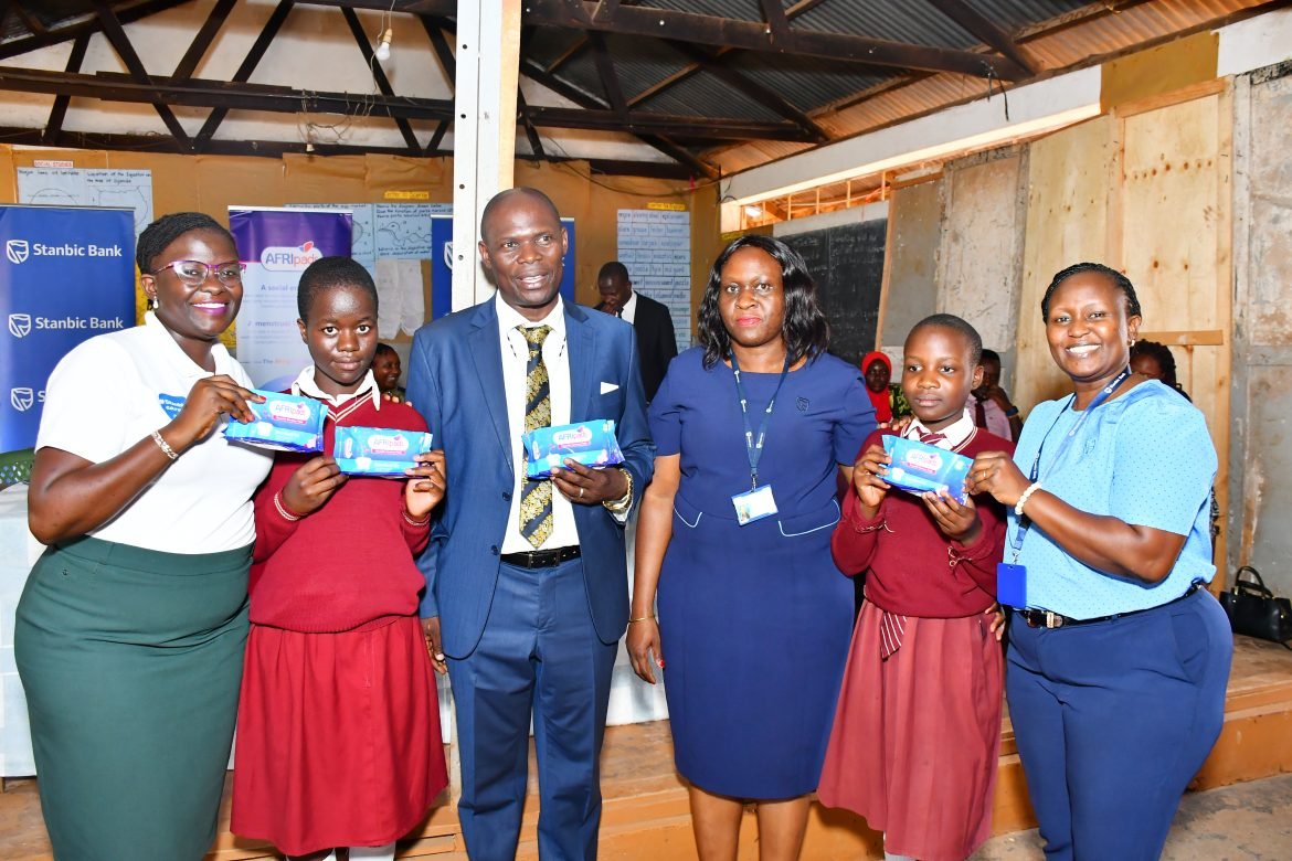 Stanbic Bank team led Head of CSI Diana Ondoga (L) and pose for a photo with Minister Kyofatogabye and some of the initiative beneficiaries.